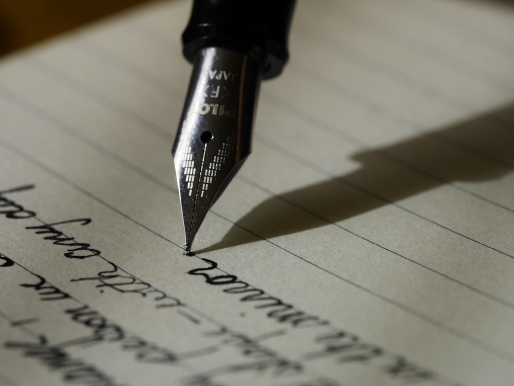 A person writing reflections in an open notebook.