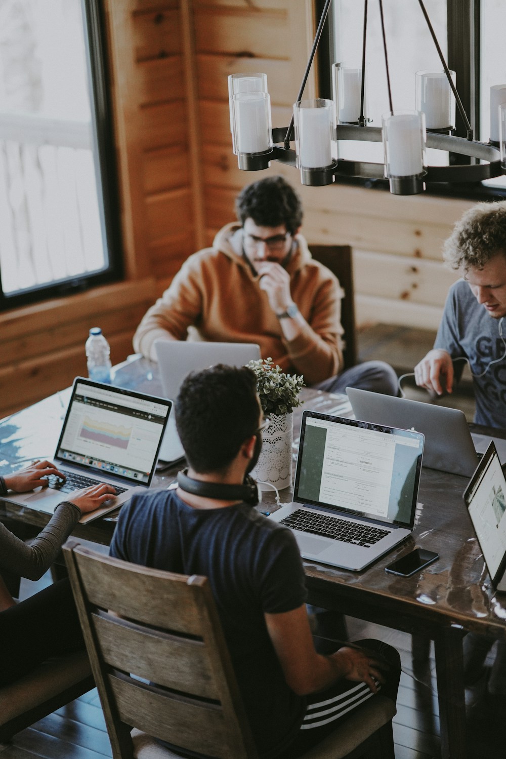 Colleagues gathered around a laptop in a bright workspace.